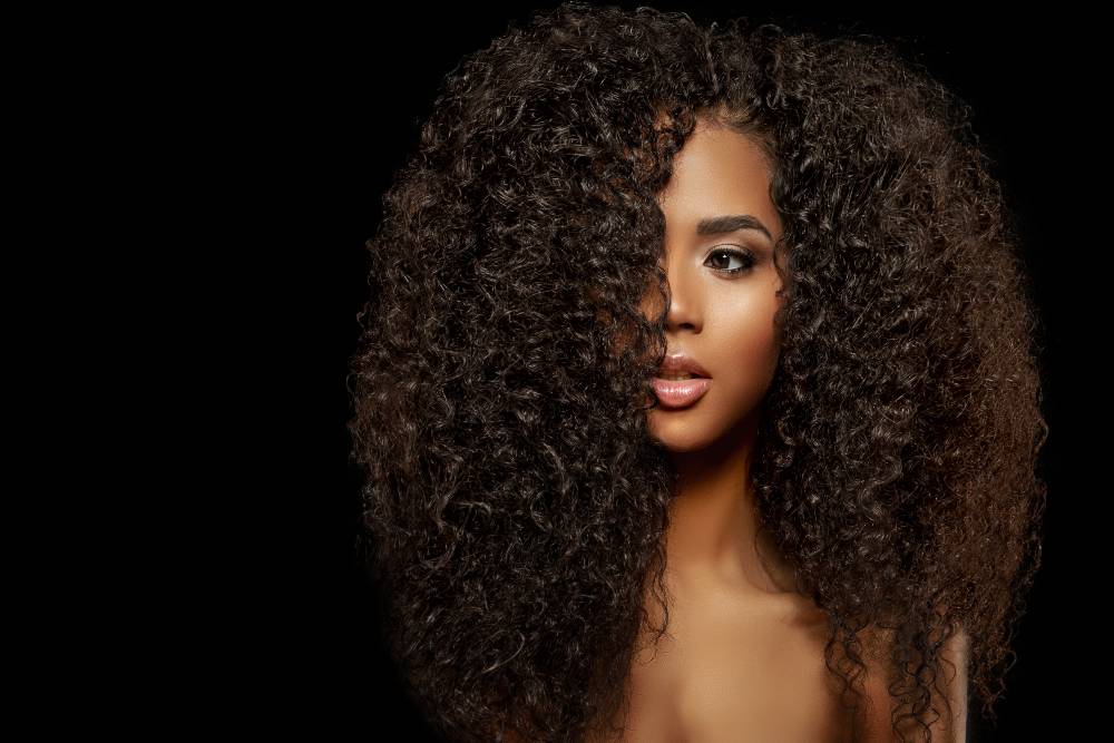 Beauty Fashion model. Black woman face &amp; beautiful voluminous hair. Afro american girl. Beauty skin female face. 
Healthy hair with luxurious Updo haircut. Waves, Curls volume Hairstyle. Hair Salon.